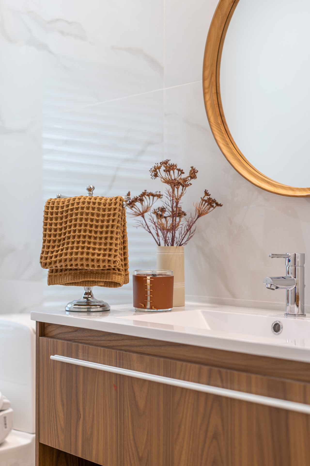 Hand-finished walnut vanity and stone surfaces in a completed bathroom